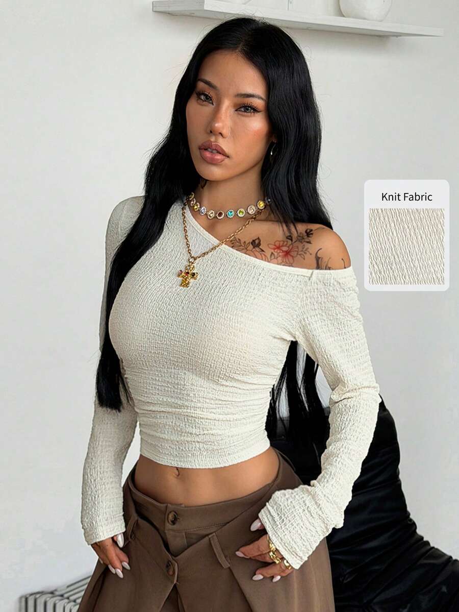 Women's slim fit long sleeve knit top featuring an asymmetrical neckline and grommet eyelet detail