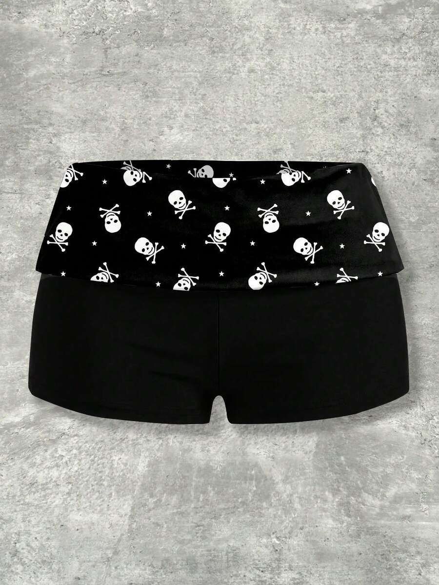 Women's black low waist mini track shorts with contrast polka dot, striped, geometric, and plant-inspired print details, elastic waistband, and skinny fit