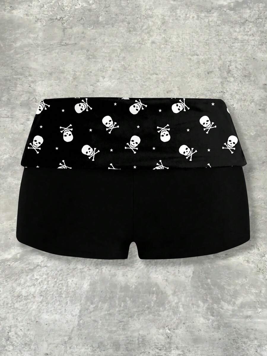 Women's black low waist mini track shorts with contrast polka dot, striped, geometric, and plant-inspired print details, elastic waistband, and skinny fit