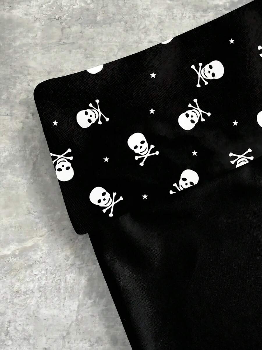 Women's black low waist mini track shorts with contrast polka dot, striped, geometric, and plant-inspired print details, elastic waistband, and skinny fit