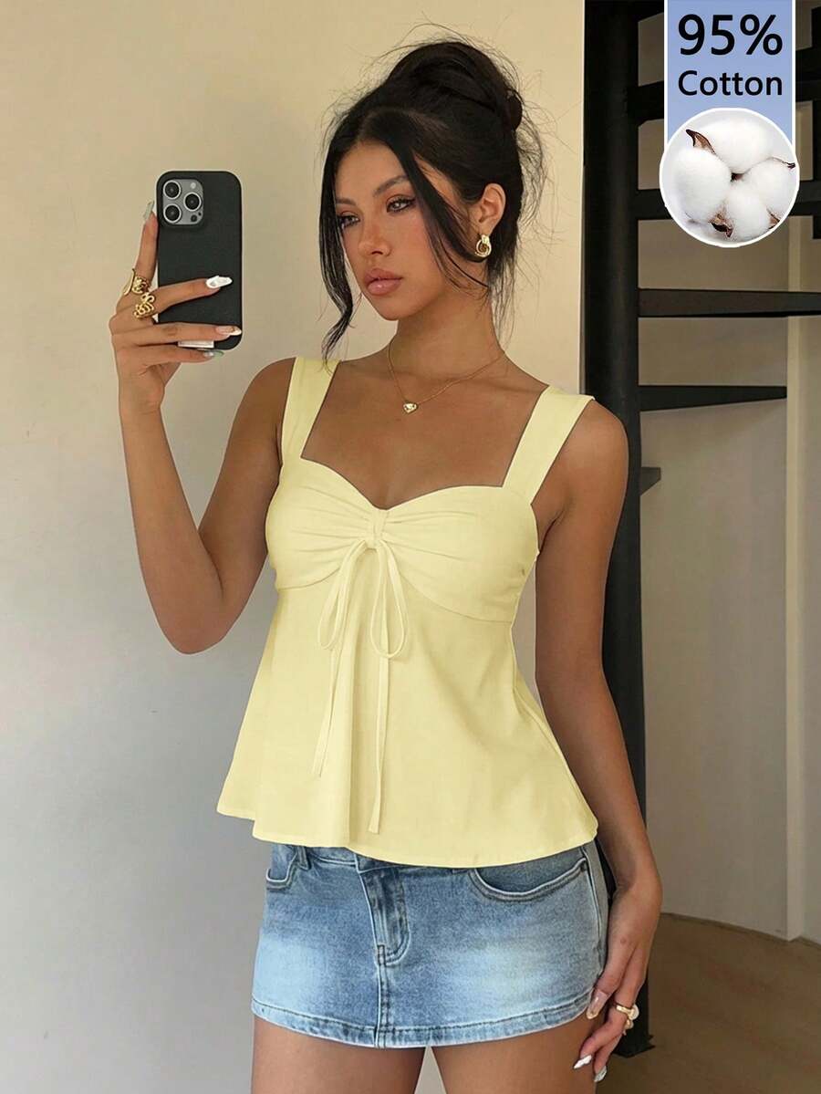Women's white wide strap tank top with drawstring front, eyelet embroidery, ruffle hem, slim fit, and flared hem.
