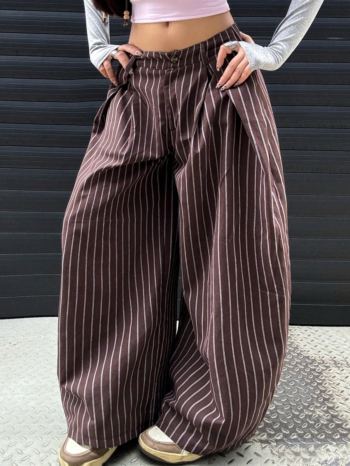 Women's brown striped wide leg pants with a low waist, curved hem, and loose casual fit in woven fabric.