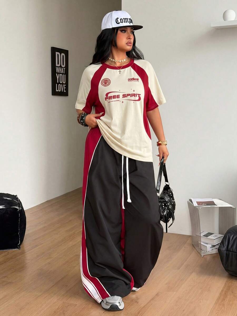 Unisex plus size oversized jersey t-shirt in brown featuring a round neck, short raglan sleeves with contrast binding, and a front letter graphic print.
