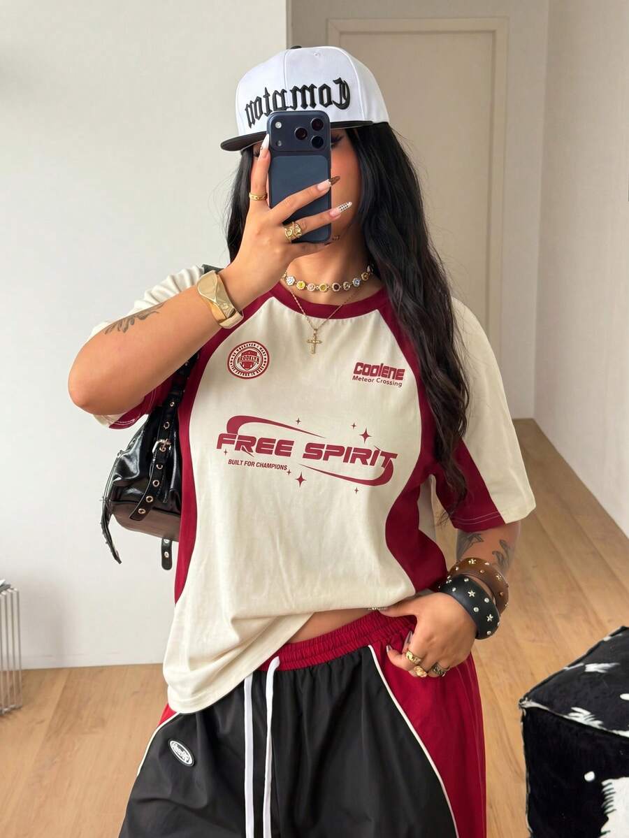 Unisex plus size oversized jersey t-shirt in brown featuring a round neck, short raglan sleeves with contrast binding, and a front letter graphic print.