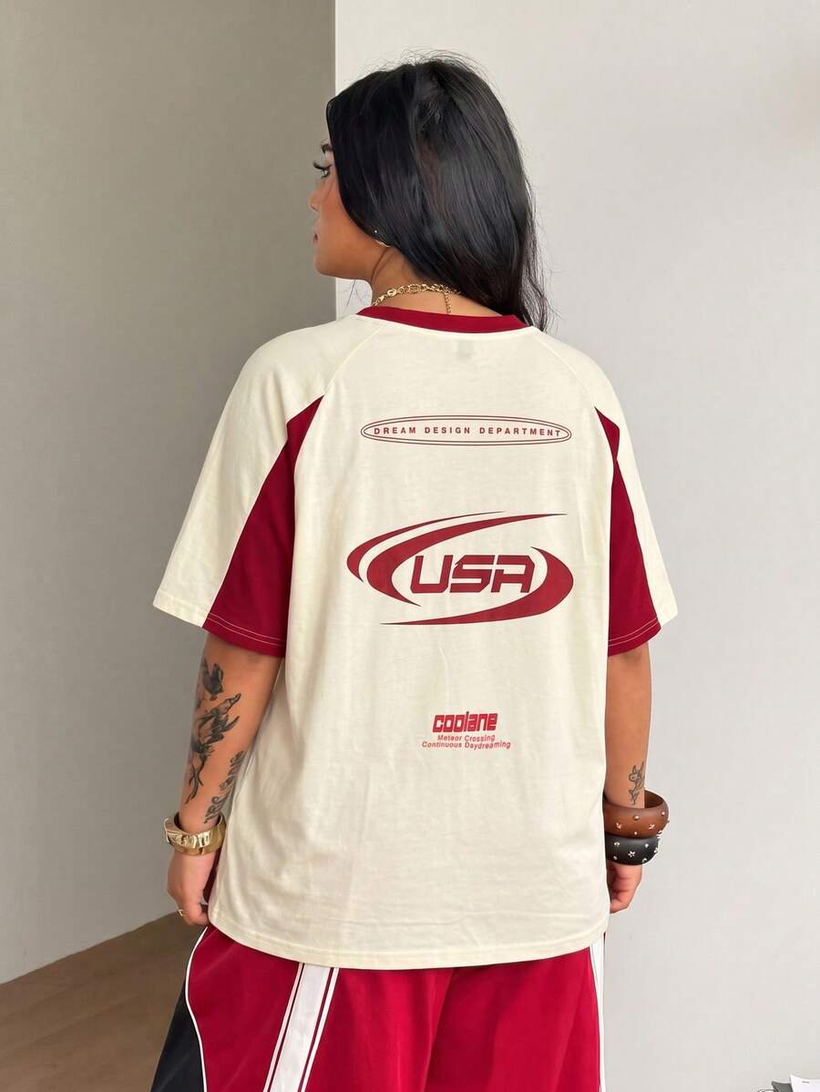 Unisex plus size oversized jersey t-shirt in brown featuring a round neck, short raglan sleeves with contrast binding, and a front letter graphic print.