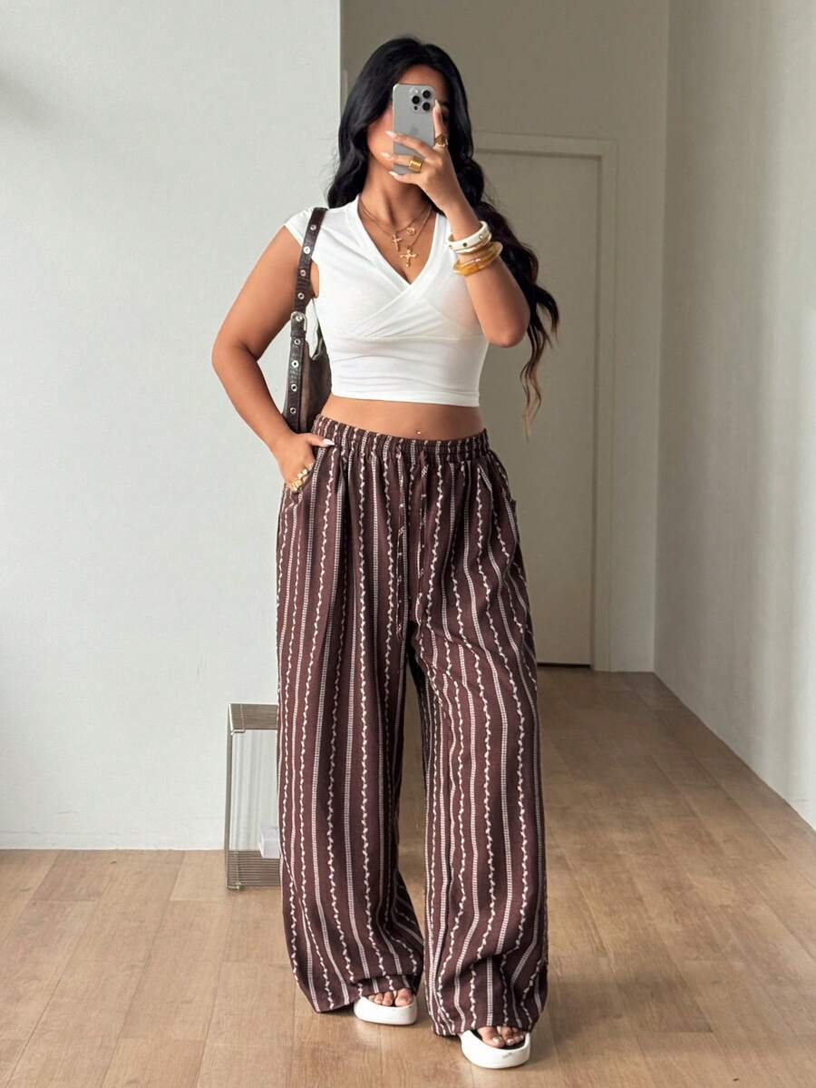 Women's loose straight leg cotton pants featuring a high waist with an adjustable drawstring knot and functional side pockets.