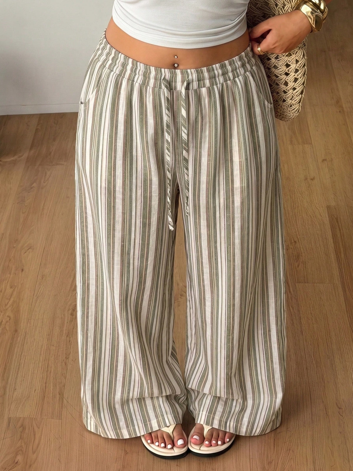 Women's loose straight leg cotton pants featuring a high waist with an adjustable drawstring knot and functional side pockets.