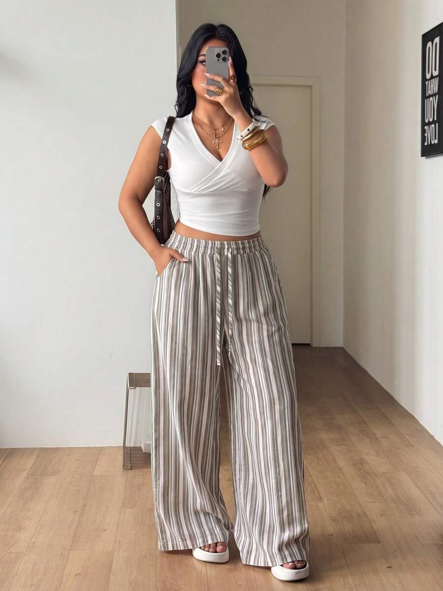 Women's loose straight leg cotton pants featuring a high waist with an adjustable drawstring knot and functional side pockets.
