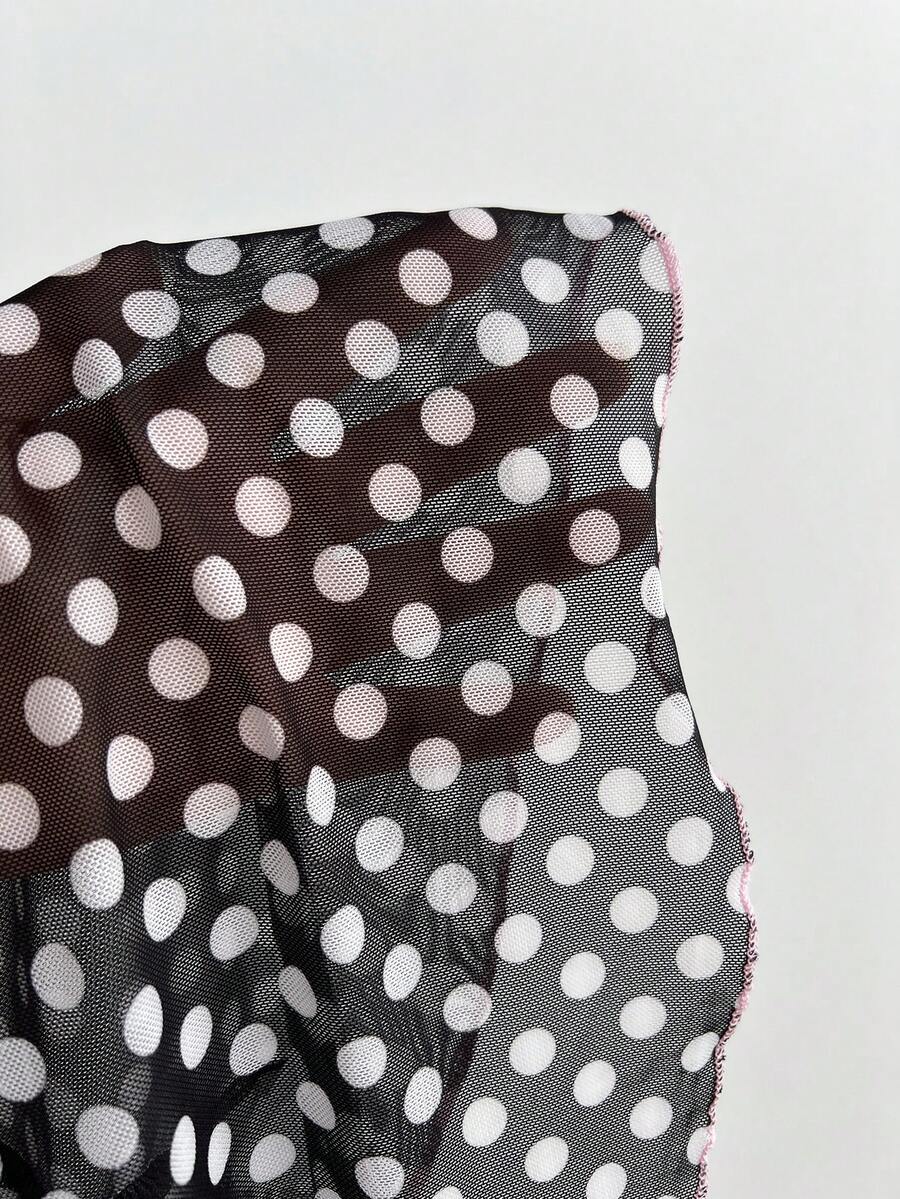 Multicolor polka dot print halter neck tank top featuring a 3D bow accent, backless tie straps, and an asymmetrical ruffle hem.