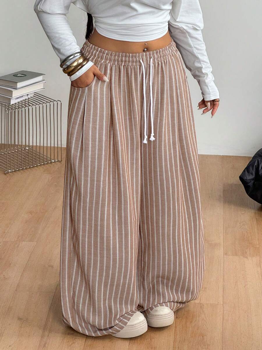 Women's loose straight leg cotton pants featuring a high waist with an adjustable drawstring knot and functional side pockets.