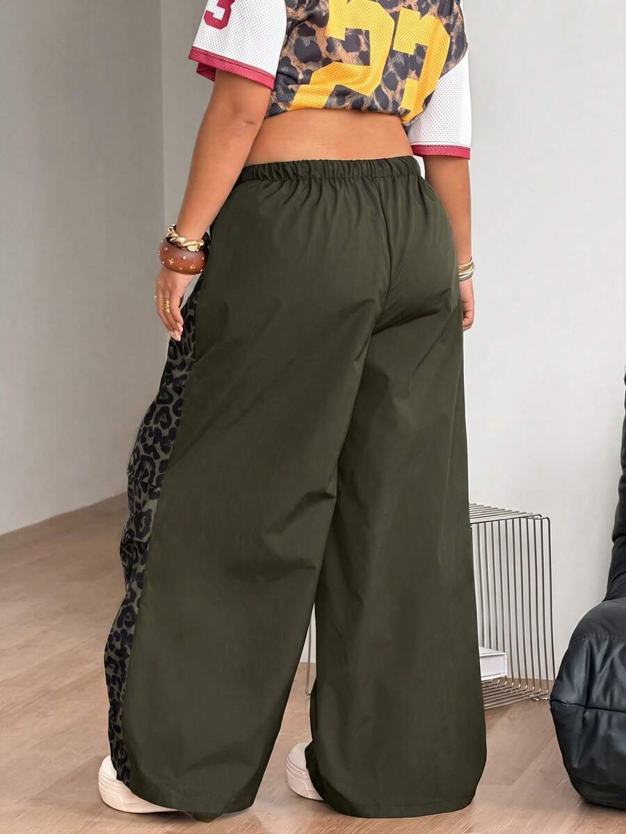 Women's high waist wide leg pants in black featuring leopard print patchwork details and an elastic drawstring waistband.