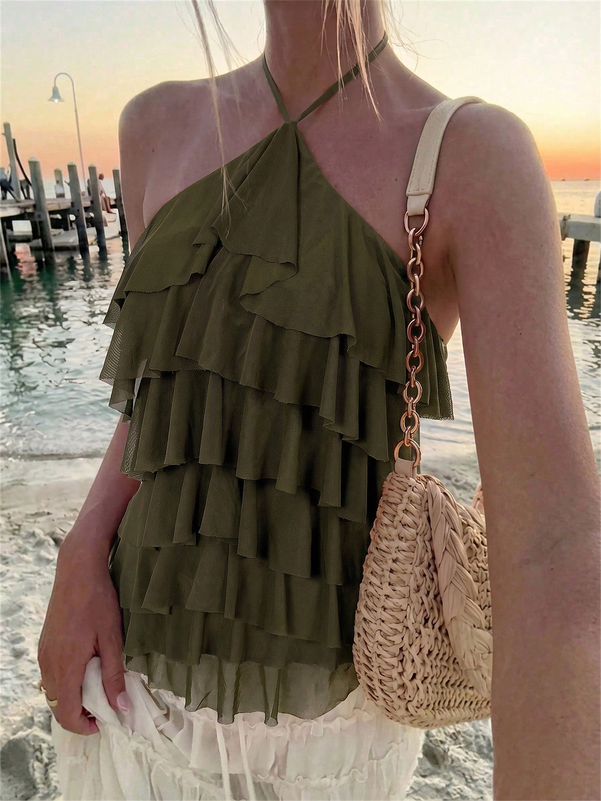 Women's sleeveless halter neck top featuring tiered ruffle layers, a backless cut, and an asymmetrical hem.
