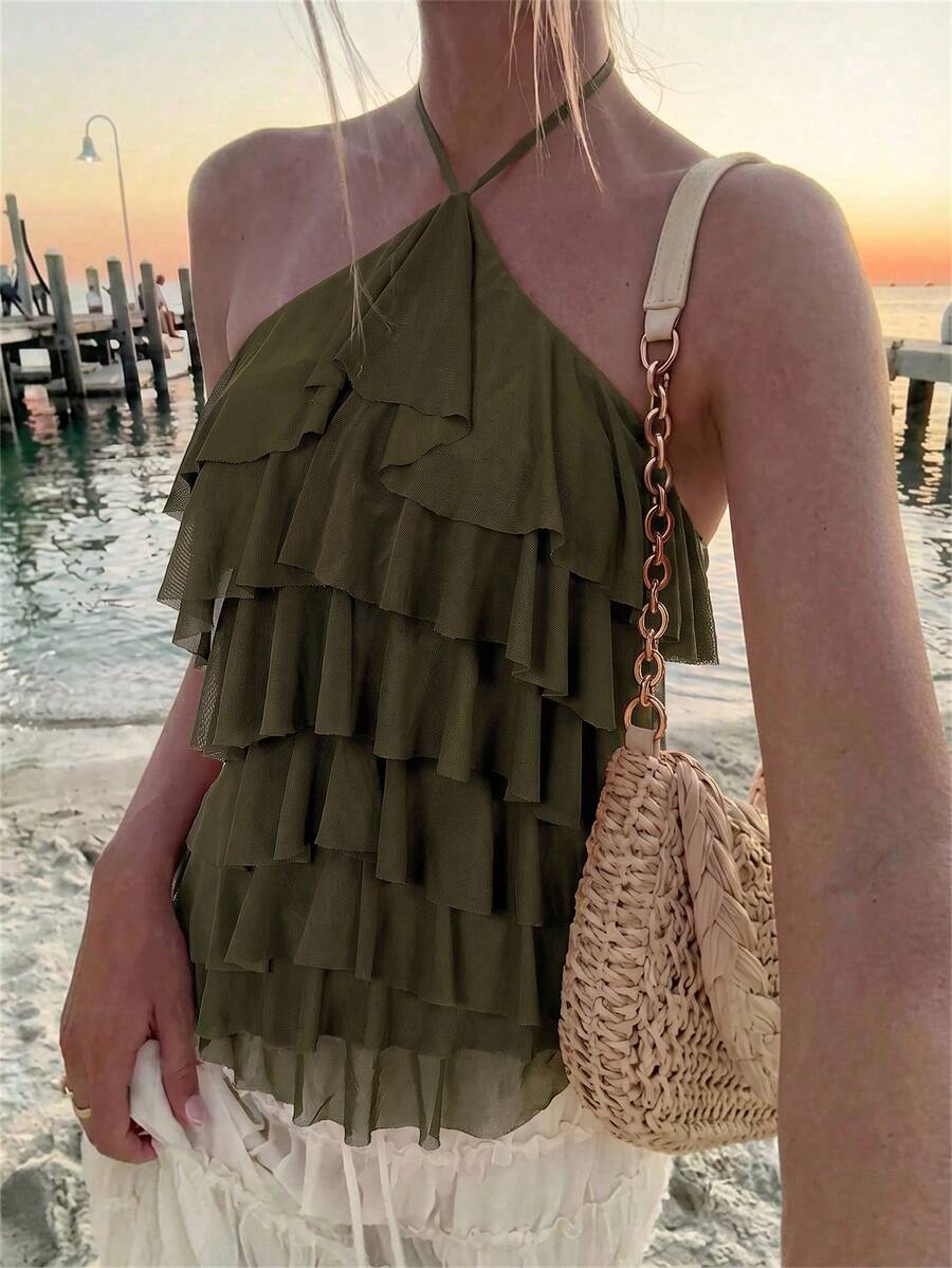 Women's sleeveless halter neck top featuring tiered ruffle layers, a backless cut, and an asymmetrical hem.