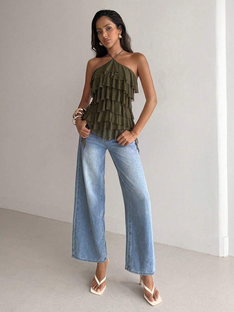 Women's sleeveless halter neck top featuring tiered ruffle layers, a backless cut, and an asymmetrical hem.