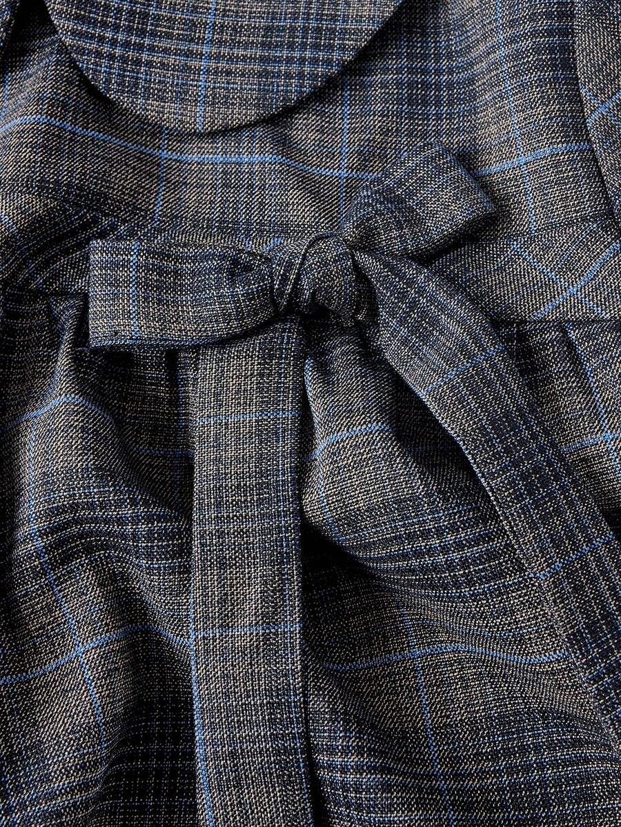 Short sleeve plaid shirt for women featuring a Peter Pan collar with a bow accent, puff sleeves, and a flared hem.
