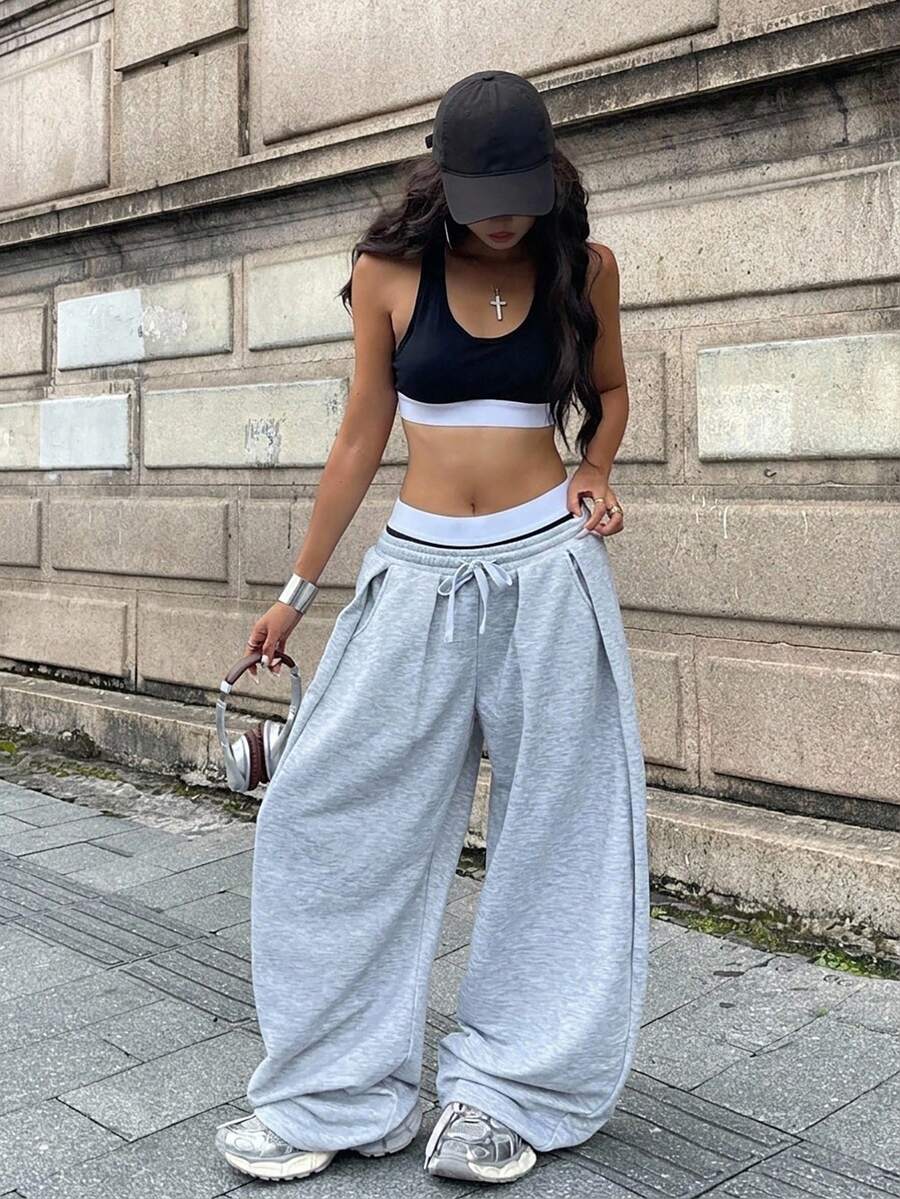 Women's casual black loose fit baggy banana pants featuring a low rise elastic drawstring waist and side pockets.