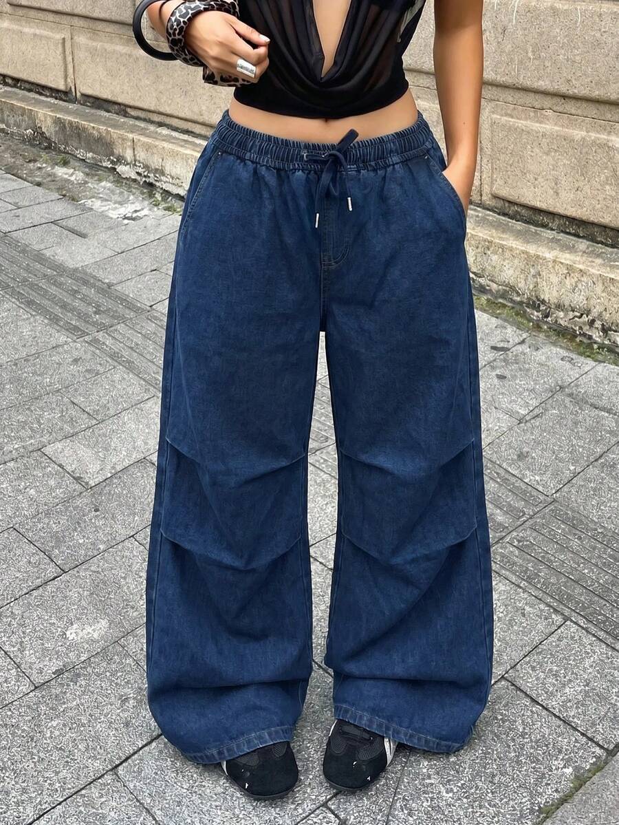 Front view of women's loose wide leg denim jeans featuring a mid waist, classic front pockets, and a zipper fly closure.