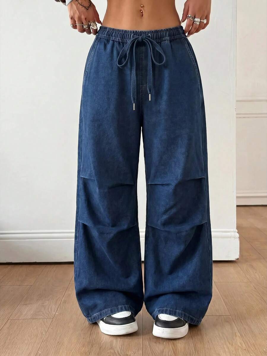 Front view of women's loose wide leg denim jeans featuring a mid waist, classic front pockets, and a zipper fly closure.