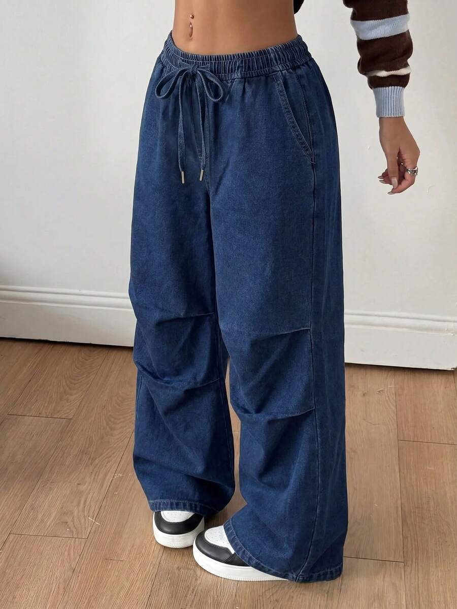Front view of women's loose wide leg denim jeans featuring a mid waist, classic front pockets, and a zipper fly closure.