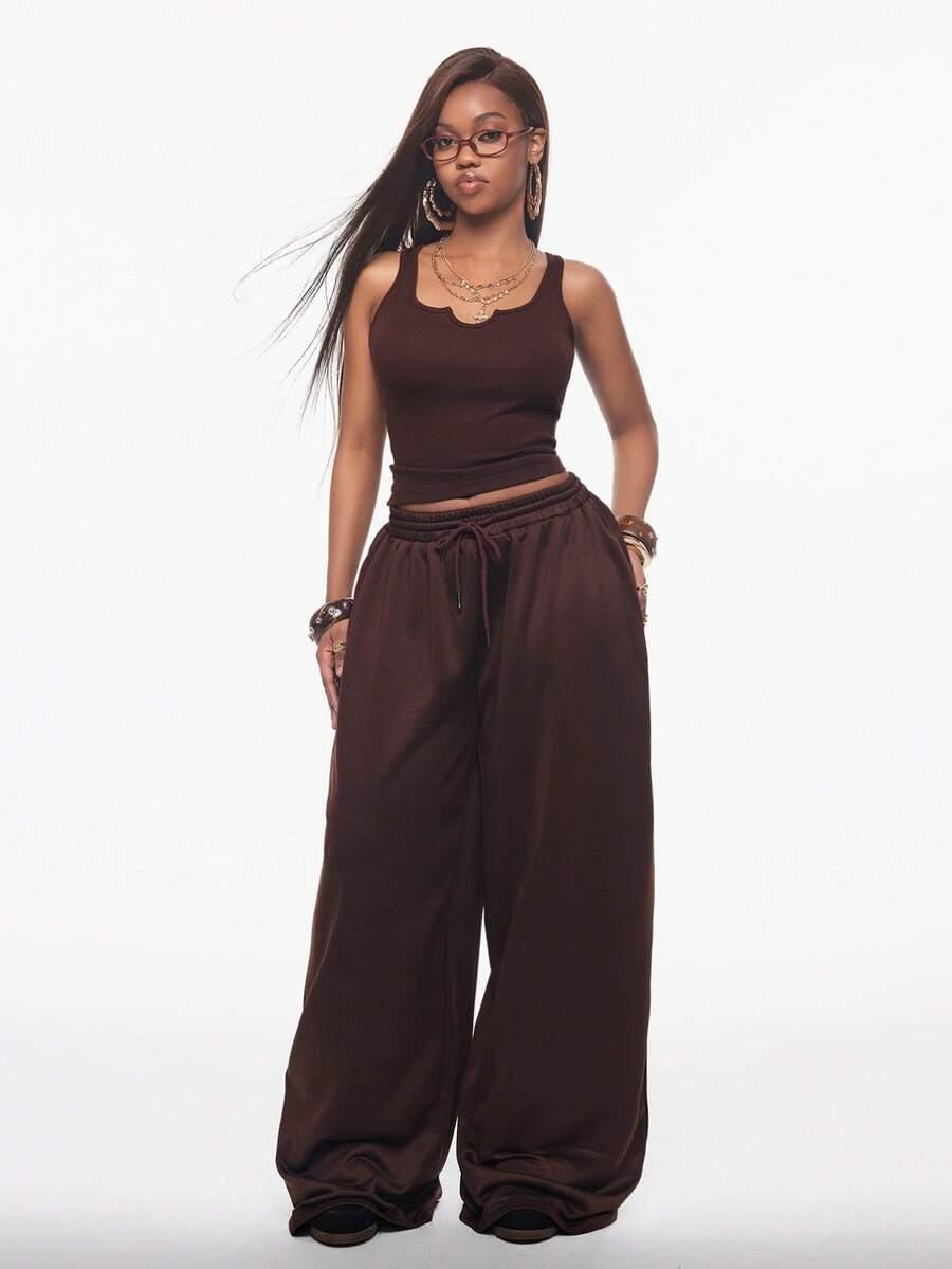 Women's two-piece casual outfit featuring a slim-fit camisole tank top with ruffle trim and button front paired with high-waisted wide leg pants.