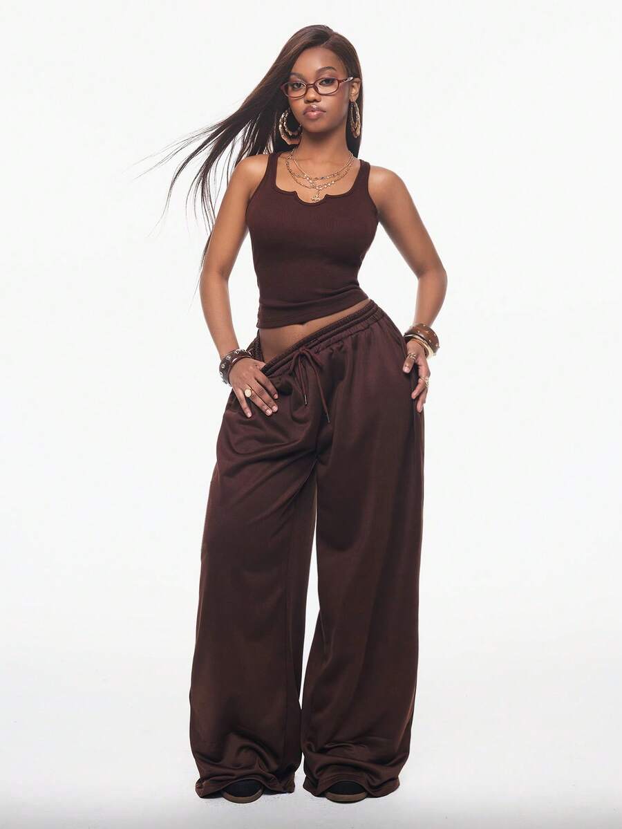 Women's two-piece casual outfit featuring a slim-fit camisole tank top with ruffle trim and button front paired with high-waisted wide leg pants.