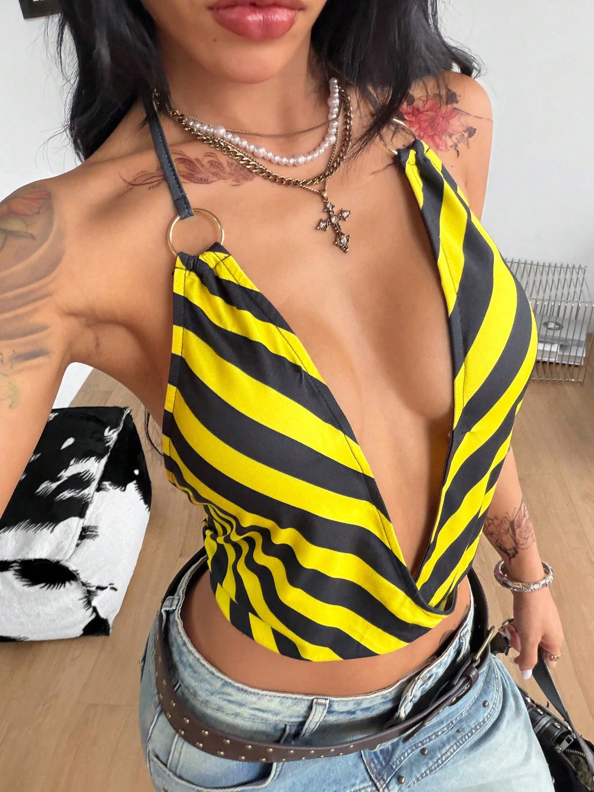 Multicolor striped halter crop tank top for women featuring a deep V-neck, metallic ring detail, and draped asymmetrical hem.