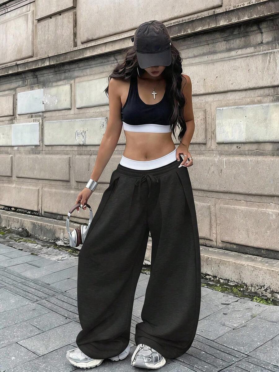 Women's casual black loose fit baggy banana pants featuring a low rise elastic drawstring waist and side pockets.