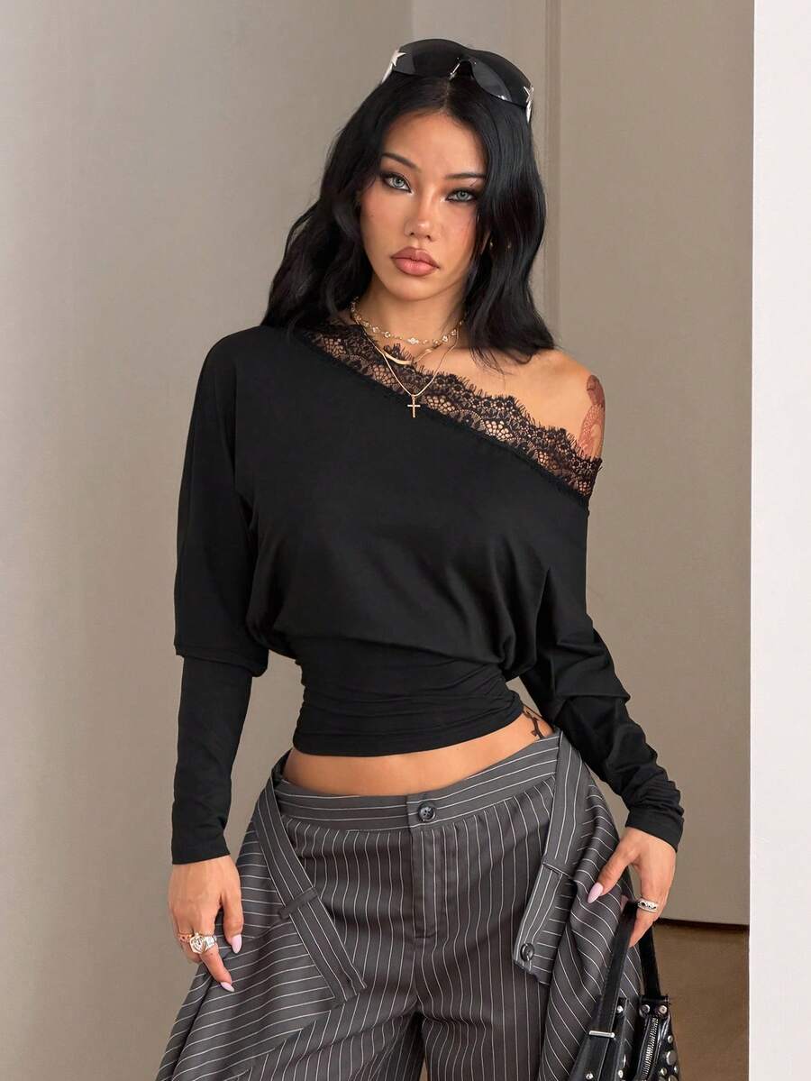 Women's black long sleeve t-shirt featuring delicate contrast lace details and a boat neckline in a knitted stretch fabric.