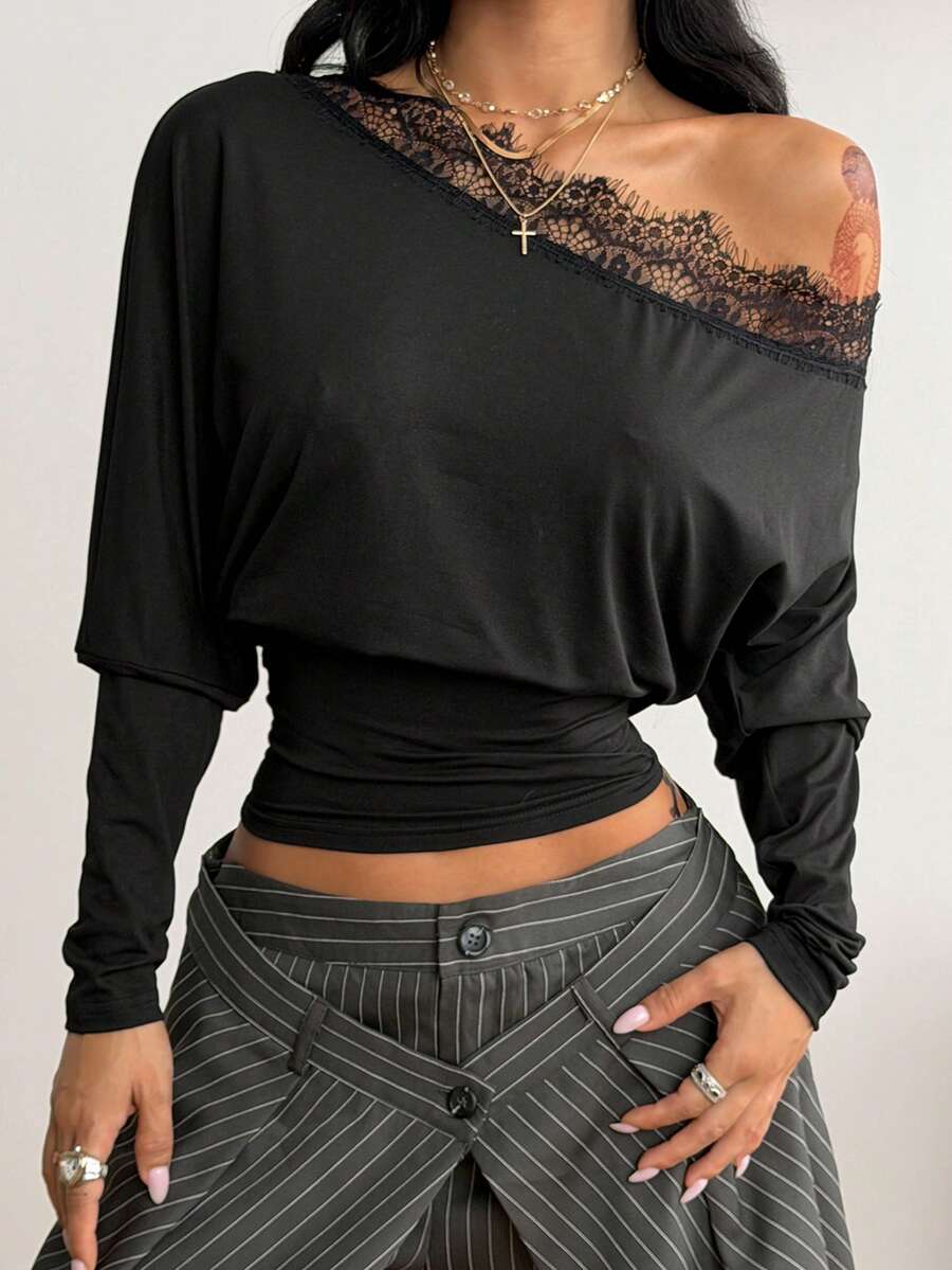 Women's black long sleeve t-shirt featuring delicate contrast lace details and a boat neckline in a knitted stretch fabric.