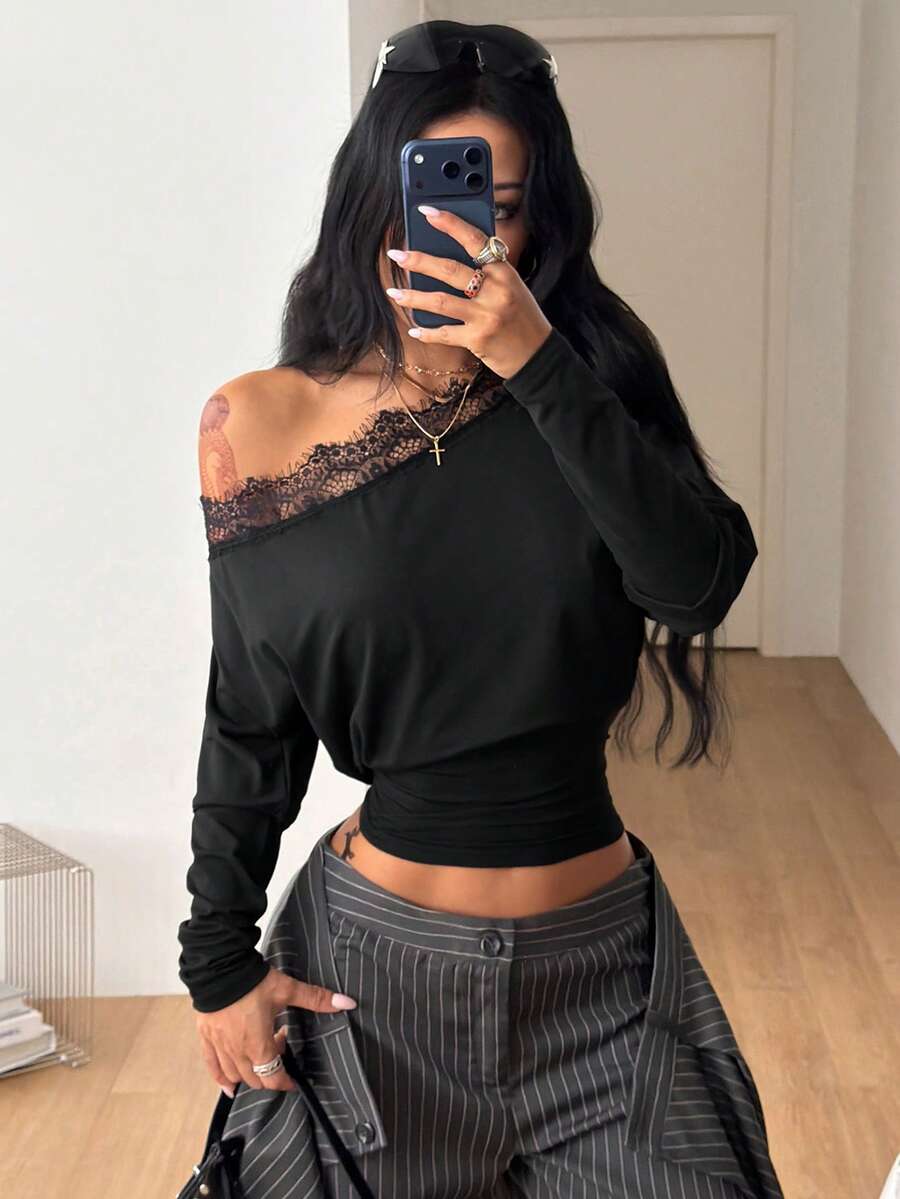 Women's black long sleeve t-shirt featuring delicate contrast lace details and a boat neckline in a knitted stretch fabric.