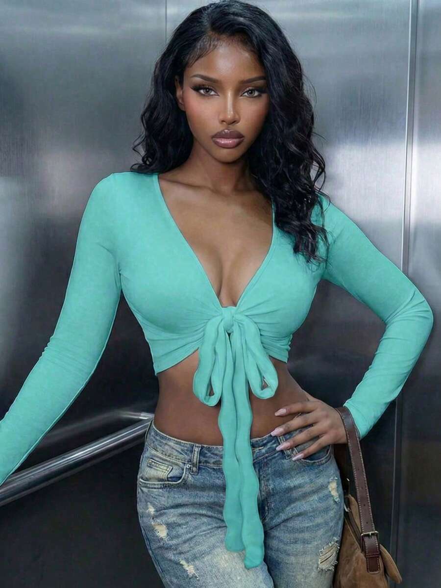 Women's mint blue cropped long sleeve top featuring a deep V-neck and twist knot asymmetrical front hem.