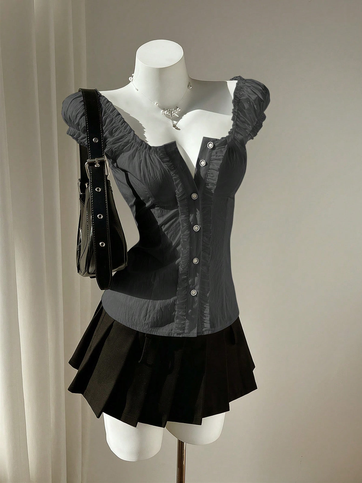 Women's black off-shoulder cap sleeve blouse with ruffled detailing and a tie-back design.