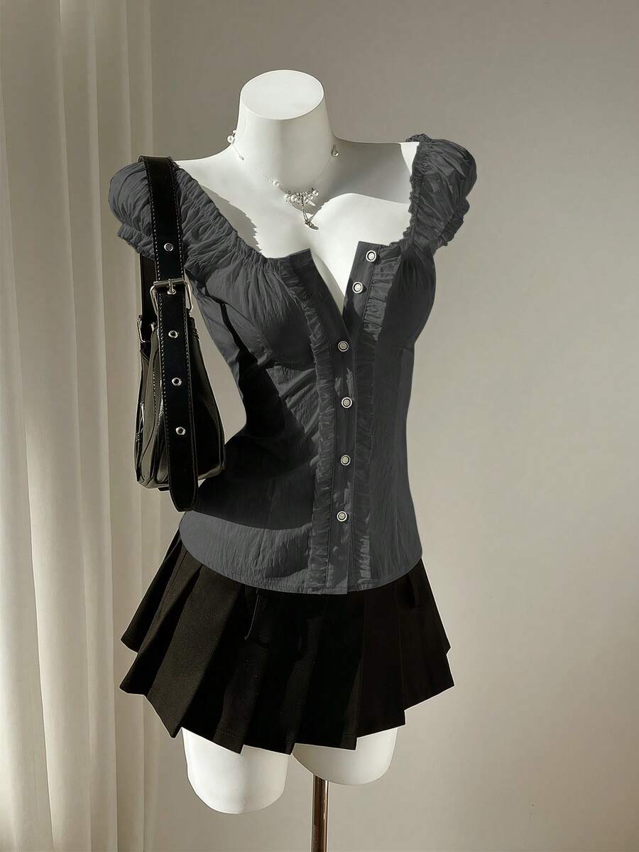 Women's black off-shoulder cap sleeve blouse with ruffled detailing and a tie-back design.