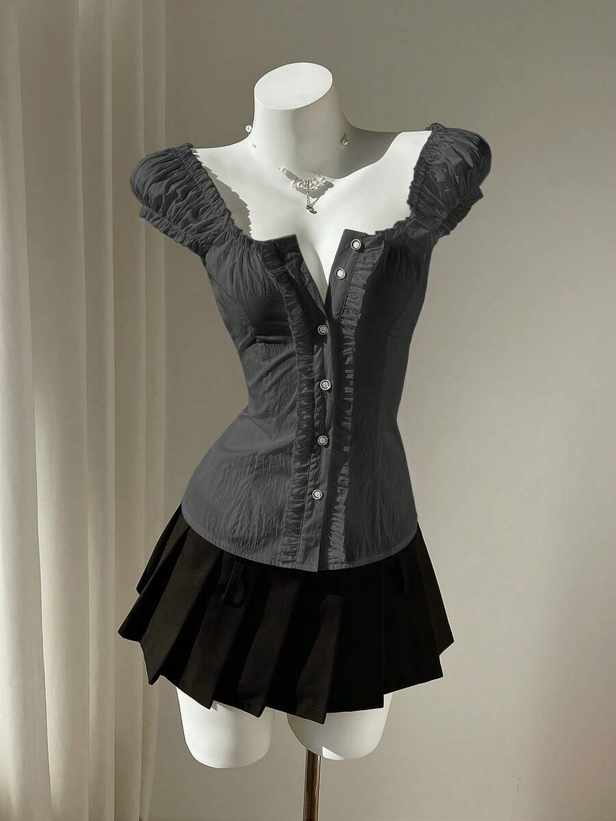 Women's black off-shoulder cap sleeve blouse with ruffled detailing and a tie-back design.