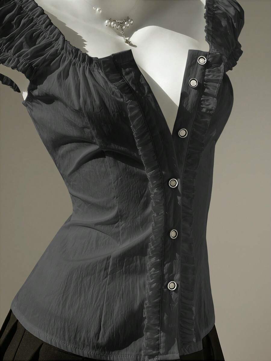 Women's black off-shoulder cap sleeve blouse with ruffled detailing and a tie-back design.