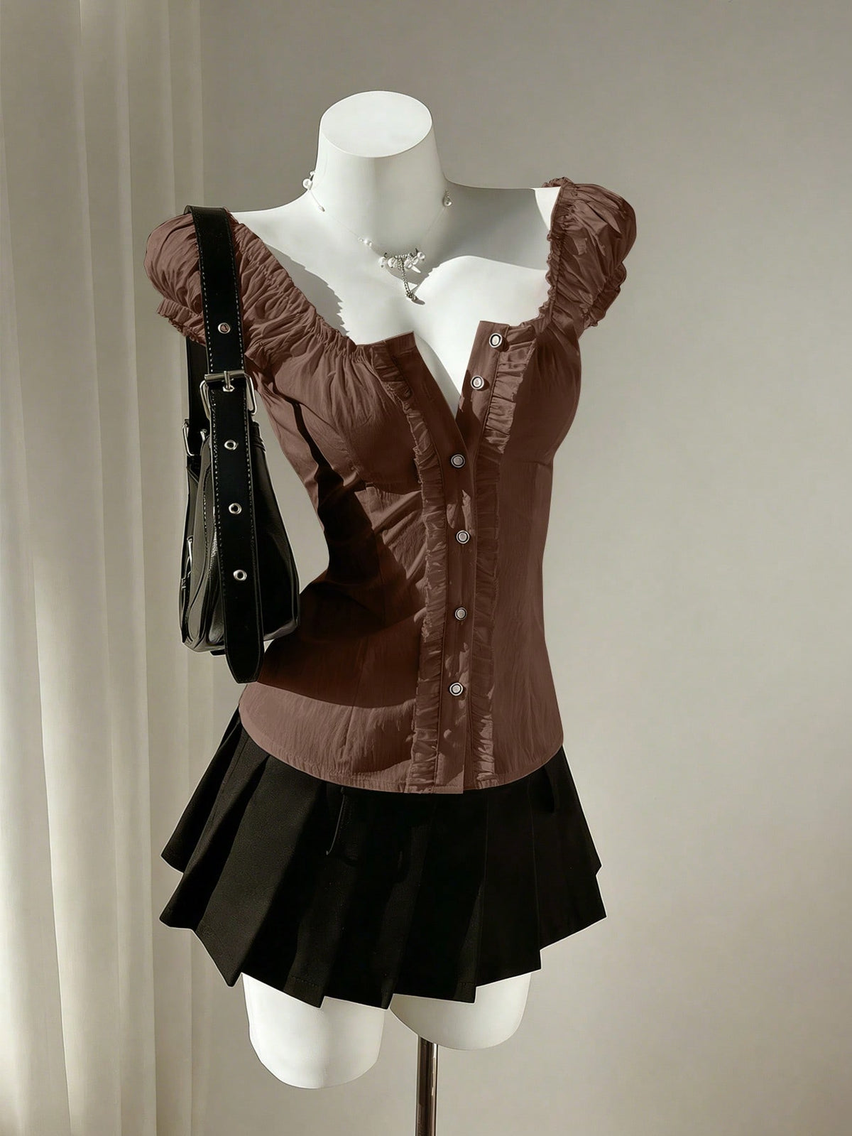 Women's black off-shoulder cap sleeve blouse with ruffled detailing and a tie-back design.