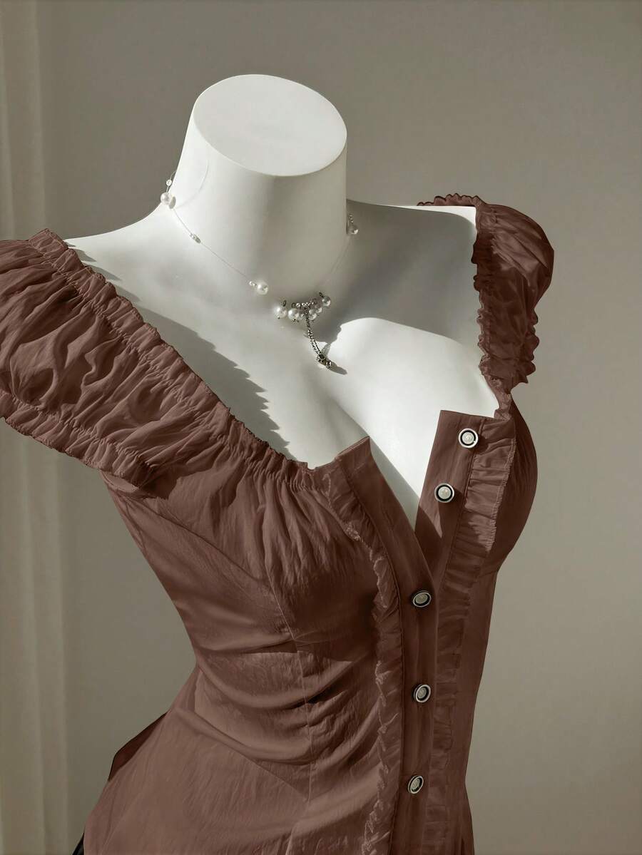 Women's black off-shoulder cap sleeve blouse with ruffled detailing and a tie-back design.