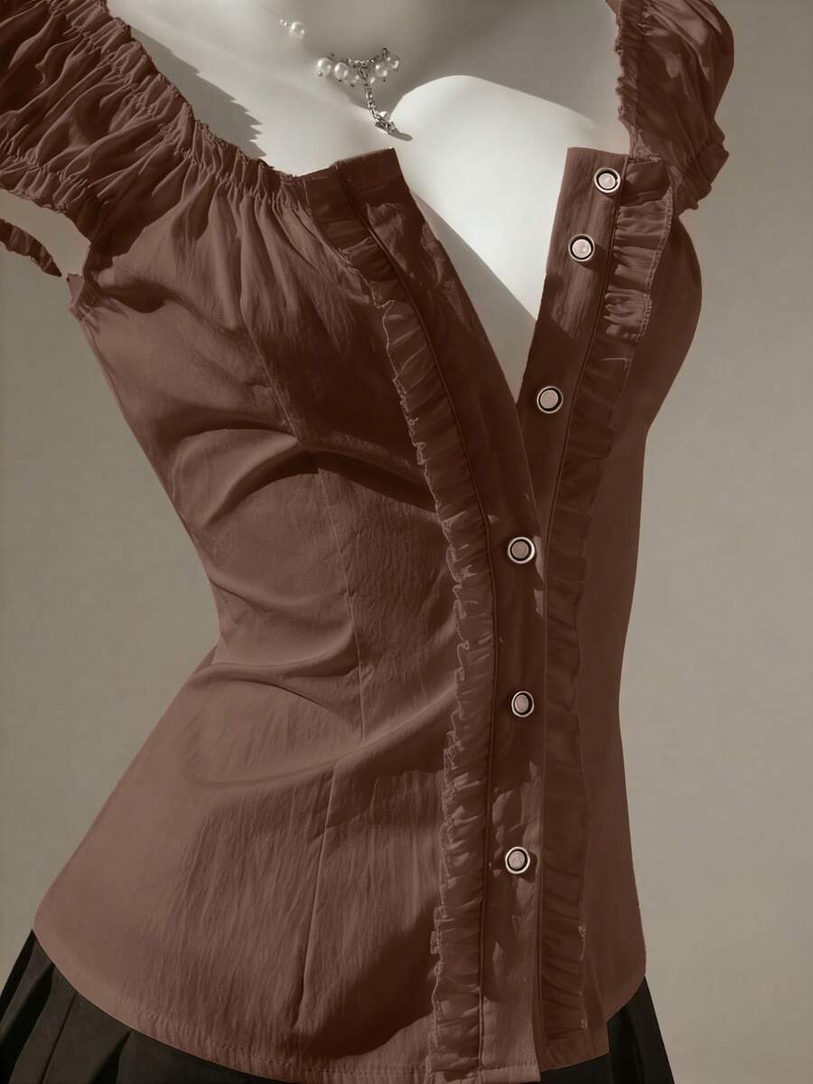 Women's black off-shoulder cap sleeve blouse with ruffled detailing and a tie-back design.