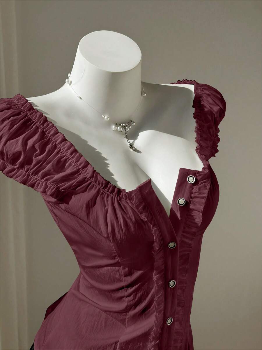 Women's black off-shoulder cap sleeve blouse with ruffled detailing and a tie-back design.