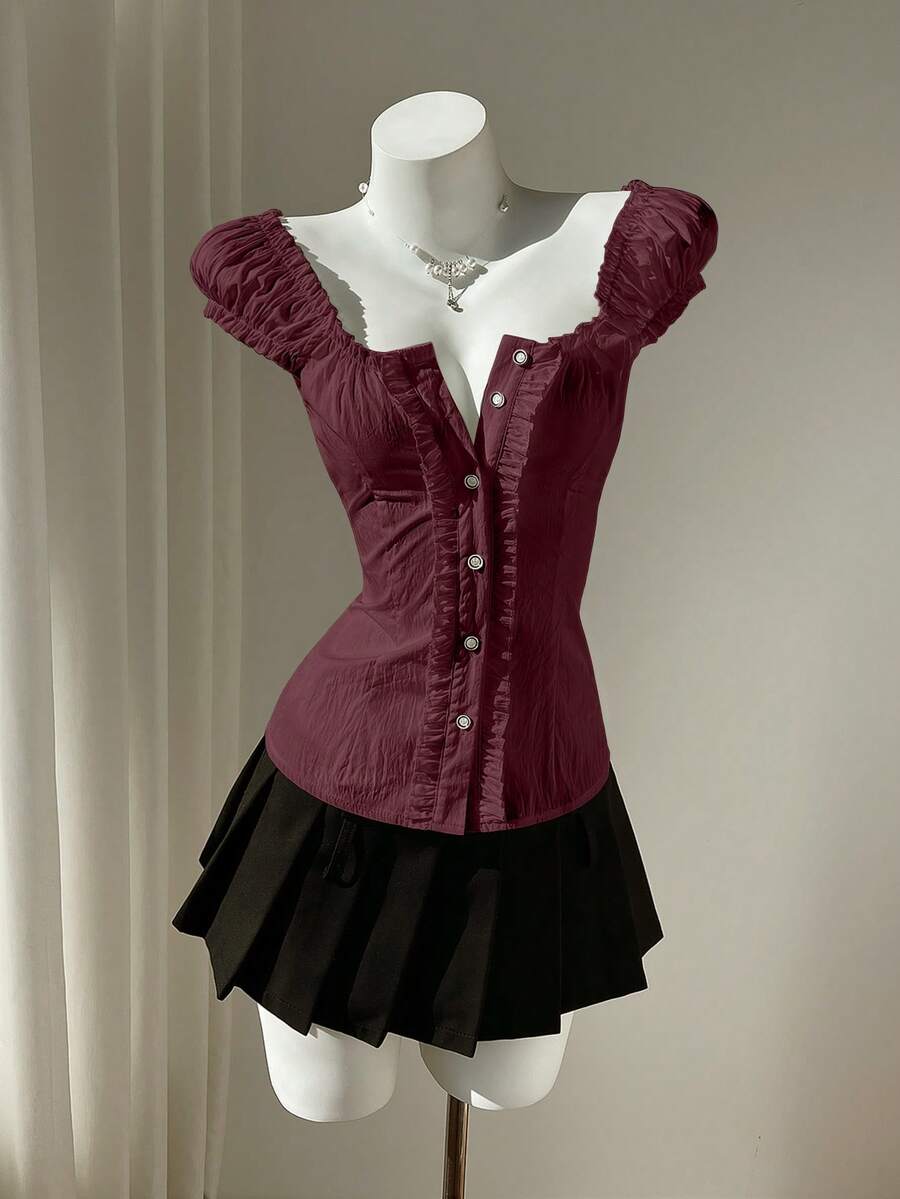 Women's black off-shoulder cap sleeve blouse with ruffled detailing and a tie-back design.