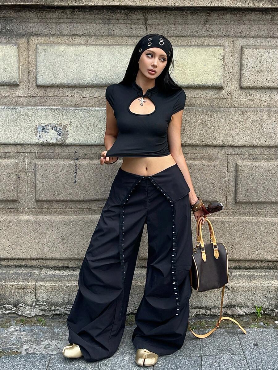 Women's low rise parachute cargo pants featuring a loose straight leg cut, functional pockets, zipper fly, and subtle studded accents.