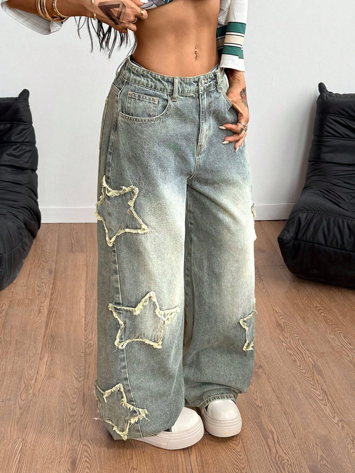 Women's loose fit baggy jeans in washed denim featuring star patches, slant pockets, and a mid-rise cut.
