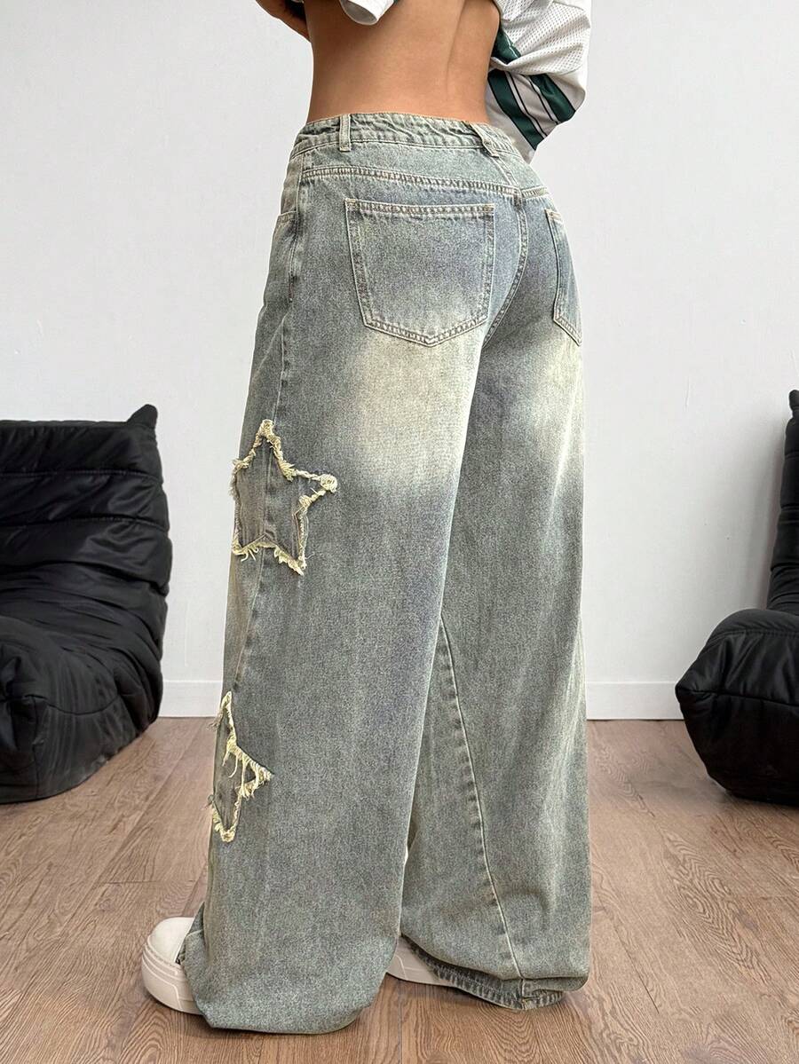 Women's loose fit baggy jeans in washed denim featuring star patches, slant pockets, and a mid-rise cut.