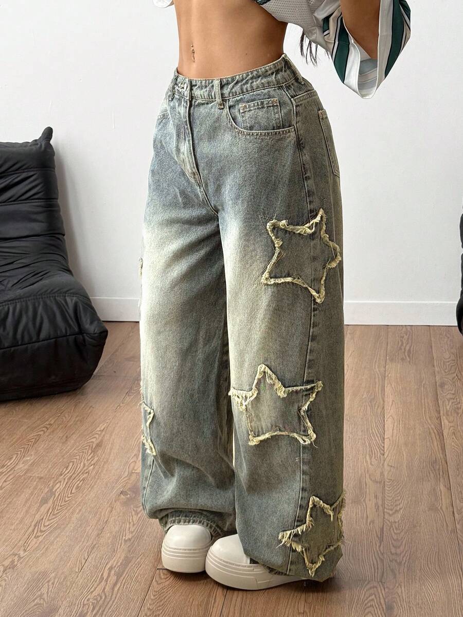 Women's loose fit baggy jeans in washed denim featuring star patches, slant pockets, and a mid-rise cut.