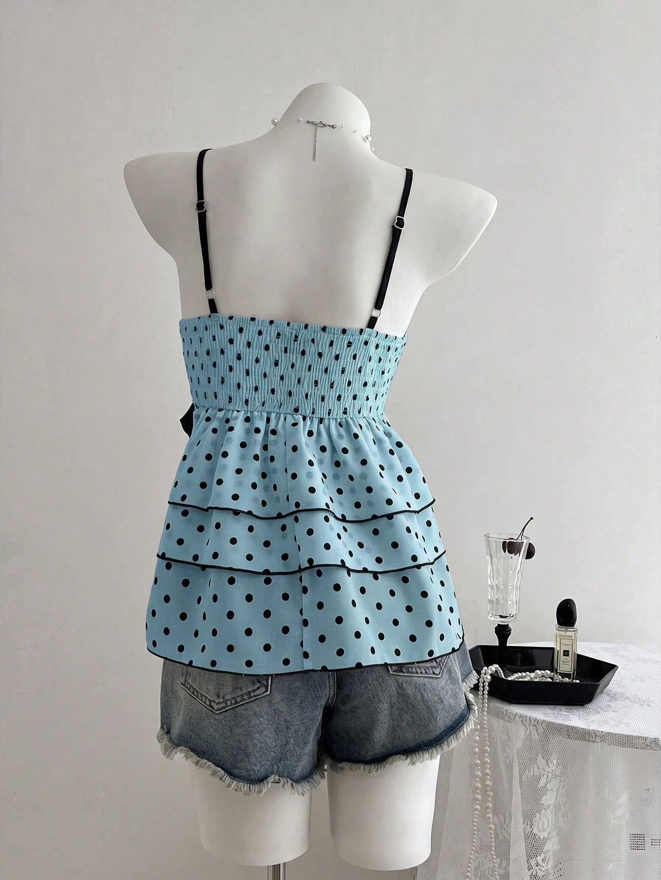 Women's polka dot camisole top with contrast lace trim, tank vest neckline, slim fit, and flared ruffle hem.