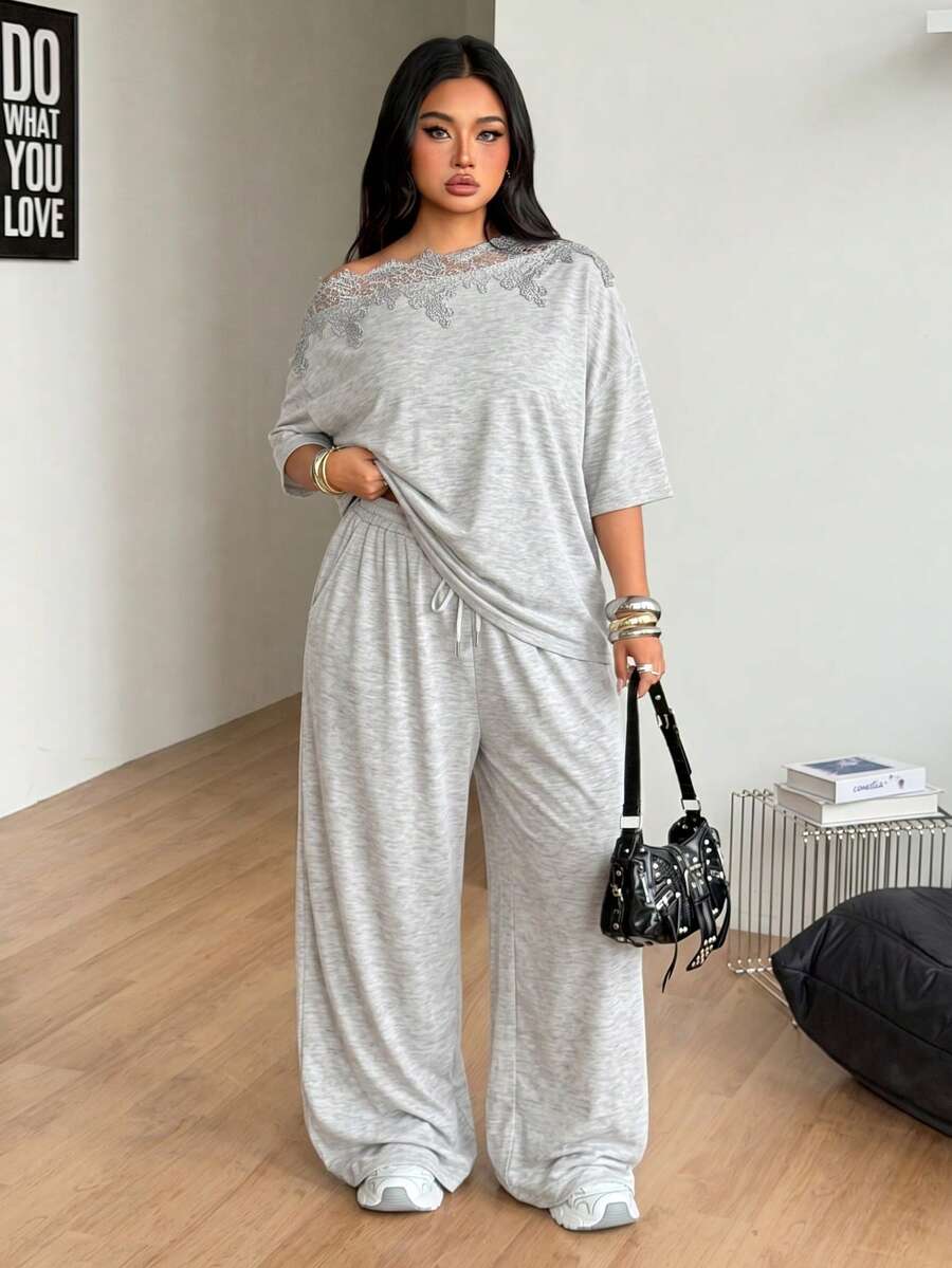 Women's casual two-piece outfit featuring a loose short-sleeve asymmetrical neck t-shirt and matching long wide leg pants with pockets.
