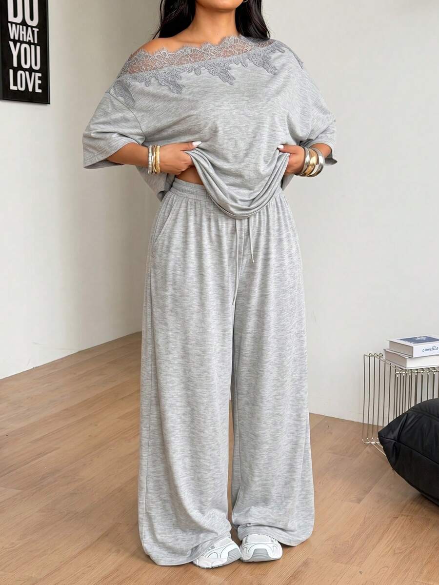Women's casual two-piece outfit featuring a loose short-sleeve asymmetrical neck t-shirt and matching long wide leg pants with pockets.