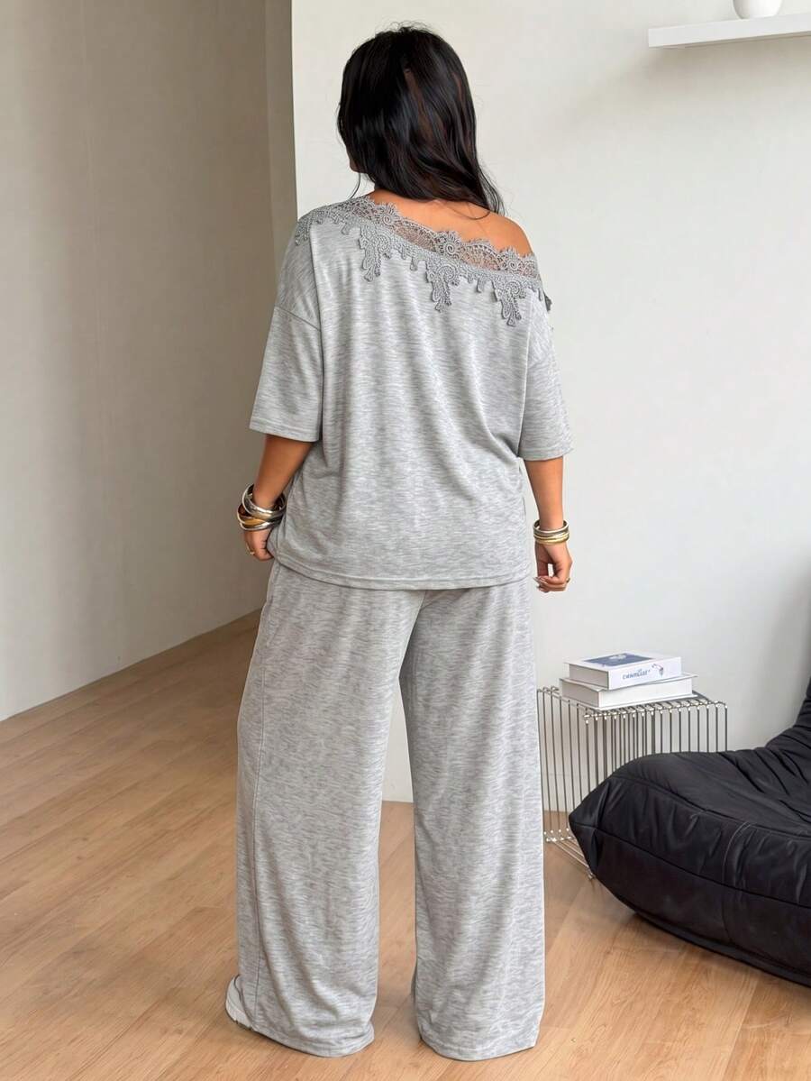 Women's casual two-piece outfit featuring a loose short-sleeve asymmetrical neck t-shirt and matching long wide leg pants with pockets.
