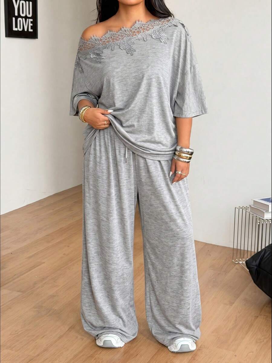 Women's casual two-piece outfit featuring a loose short-sleeve asymmetrical neck t-shirt and matching long wide leg pants with pockets.