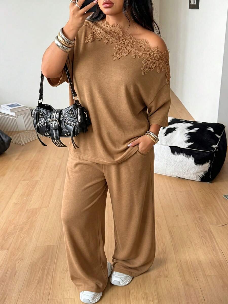 Women's casual two-piece outfit featuring a loose short-sleeve asymmetrical neck t-shirt and matching long wide leg pants with pockets.